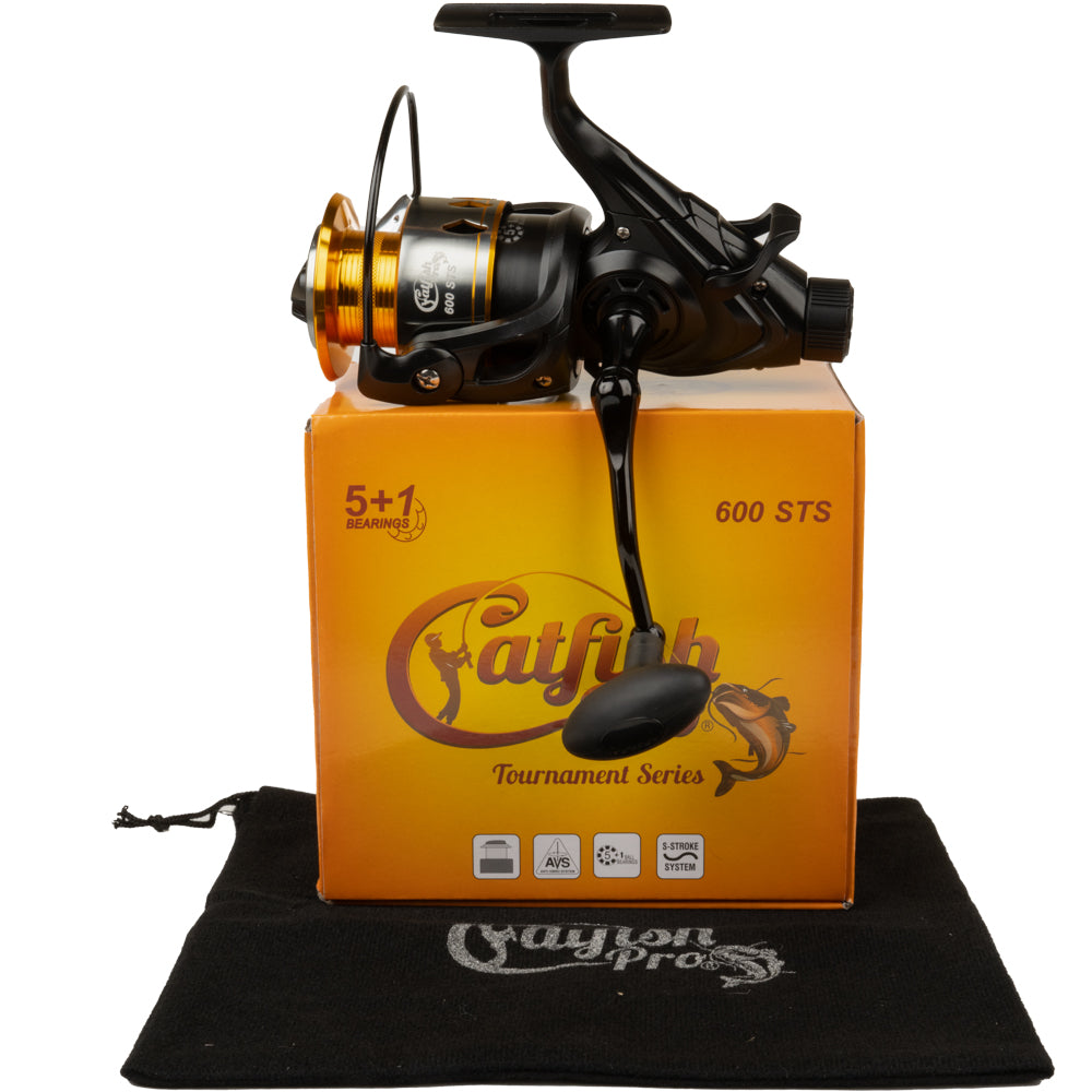 The Catfish Pro 600 STS spinning reel displayed on top of its branded orange packaging, accompanied by a black protective pouch.