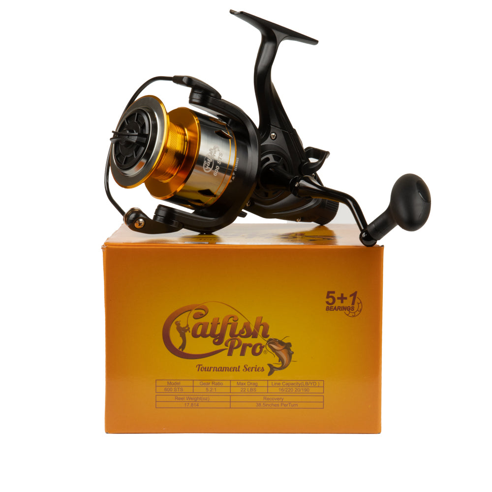 A promotional shot of the Catfish Pro 600 STS spinning reel resting on its retail box, showcasing its features and specifications.