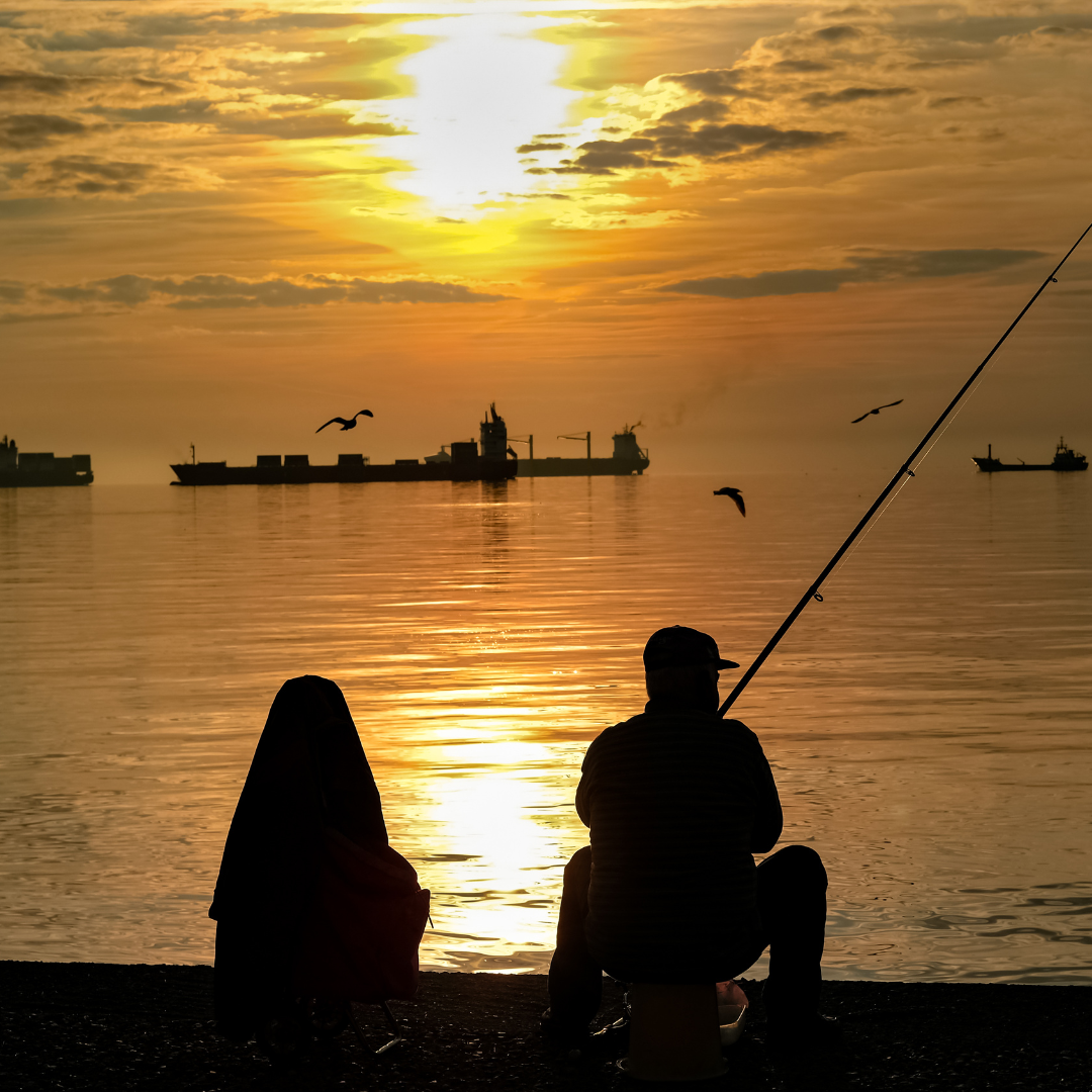 Two people fishing during the sunset 