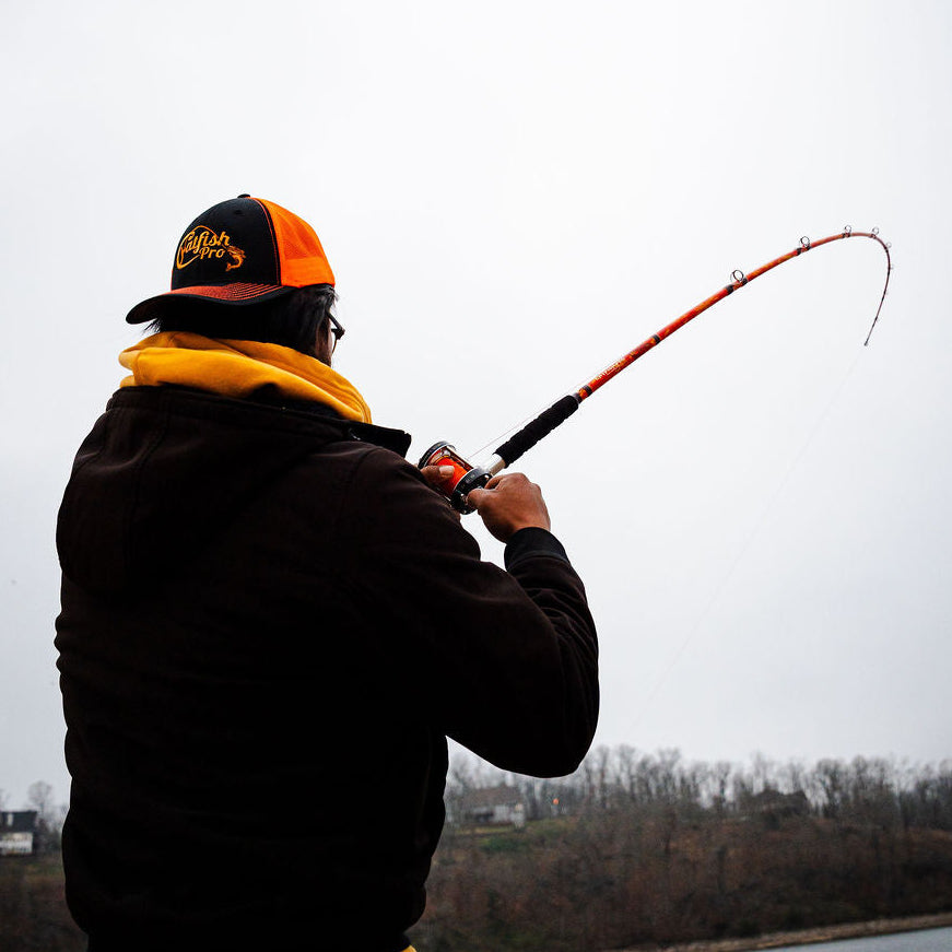 Person fishing on a lake with a cloudy sky