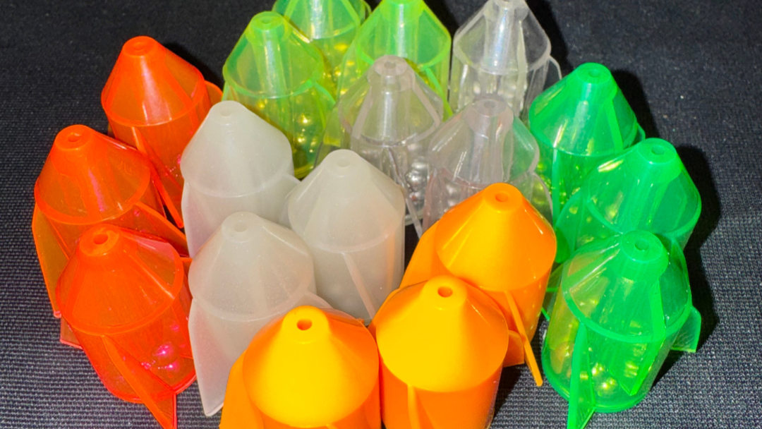 Colorful plastic fishing bobbers on a dark surface